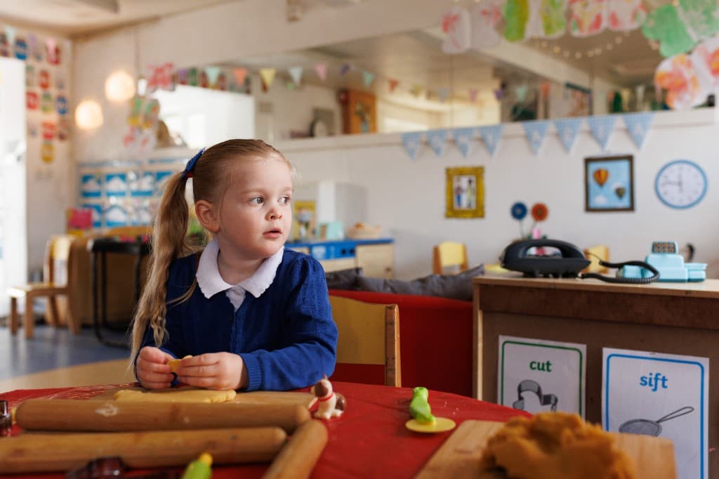 Child playing thoughtfully in a classroom at Ballybeen Women's Centre
